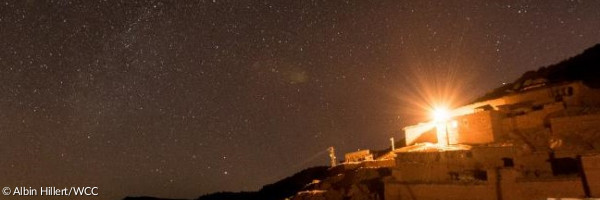 Ein helles Licht über einem orientalischen Haus in sternklarer Nacht